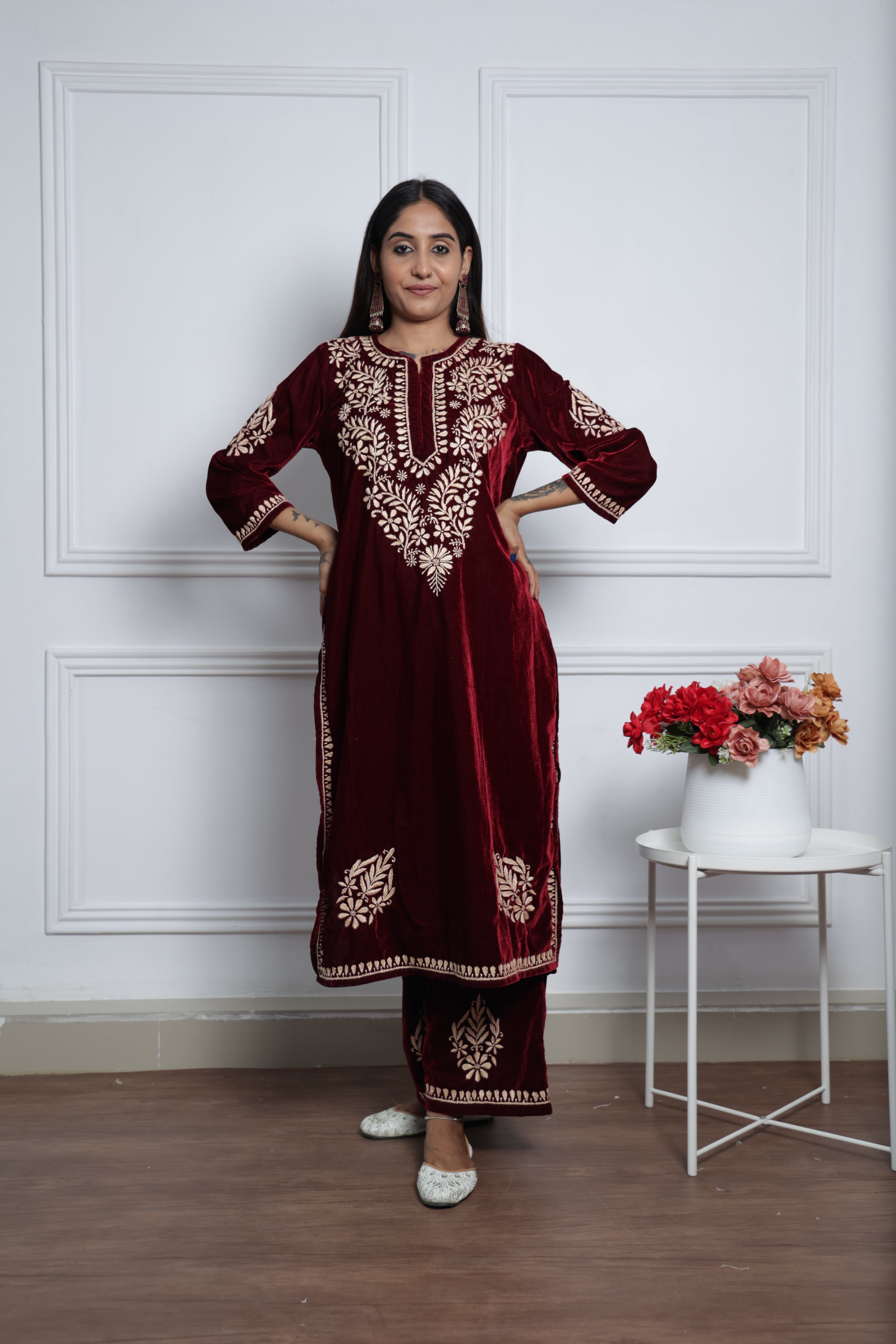 Woman wearing a maroon kurta set with white embroidery.